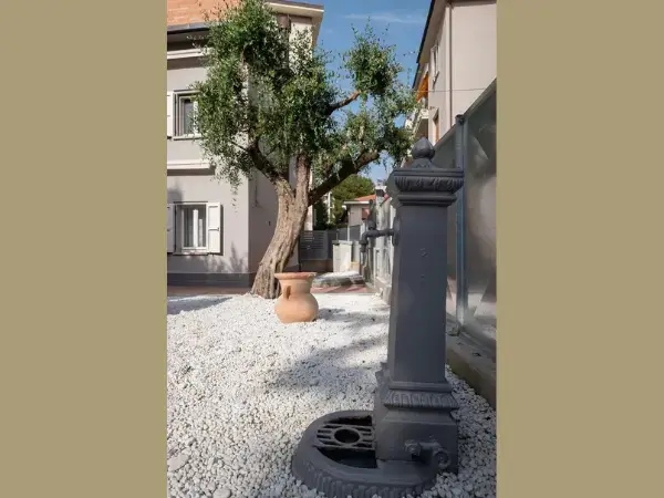 Giardino privato con ciottolato e una fontanella.