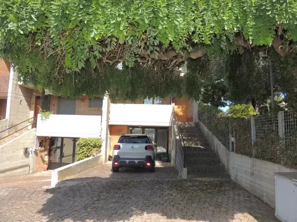 Giardino della casa a schiera con posto auto coperto.