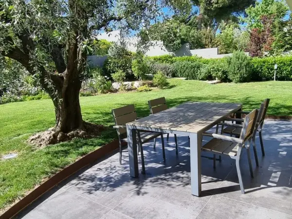 Zona pranzo esterna pavimentata e coperta con tavolo e sedie.