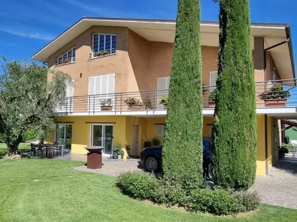 La villa con il giardino e un portico coperto con possibilità di parcheggio.